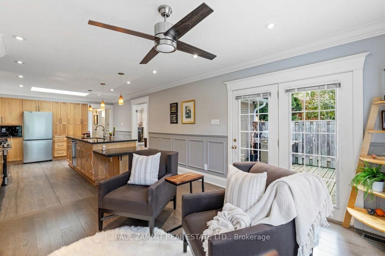 Open-plan living room and kitchen with a wood island and glass doors to a fenced patio.