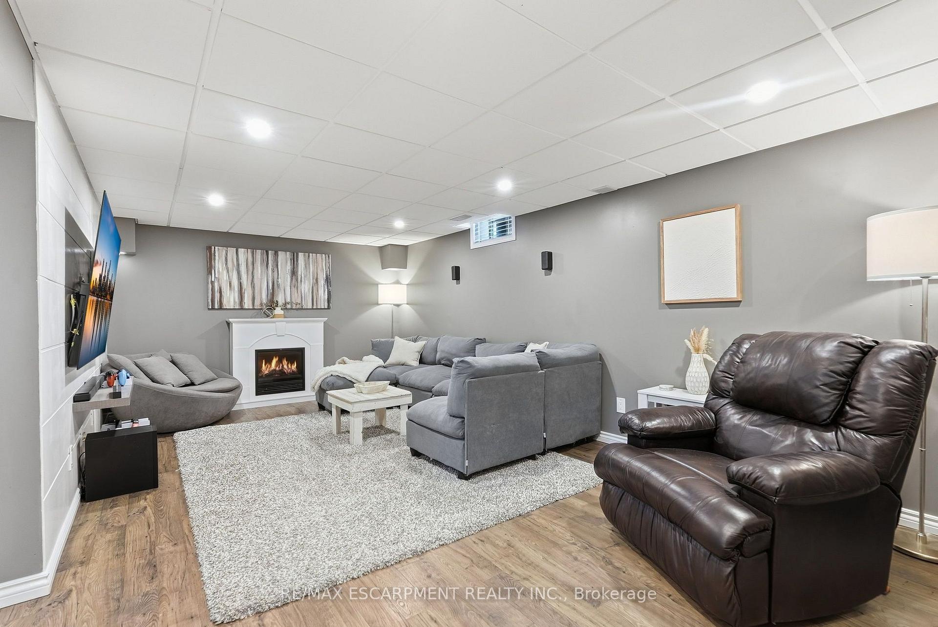 Furnished living room with gray sectional, leather recliner, and fireplace.