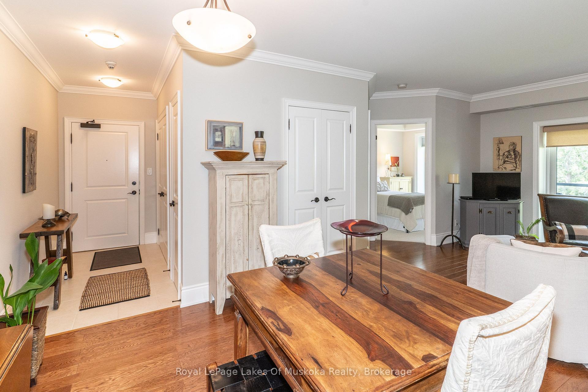 Furnished condo living room with a large wooden coffee table and bedroom visible through an open doorway.