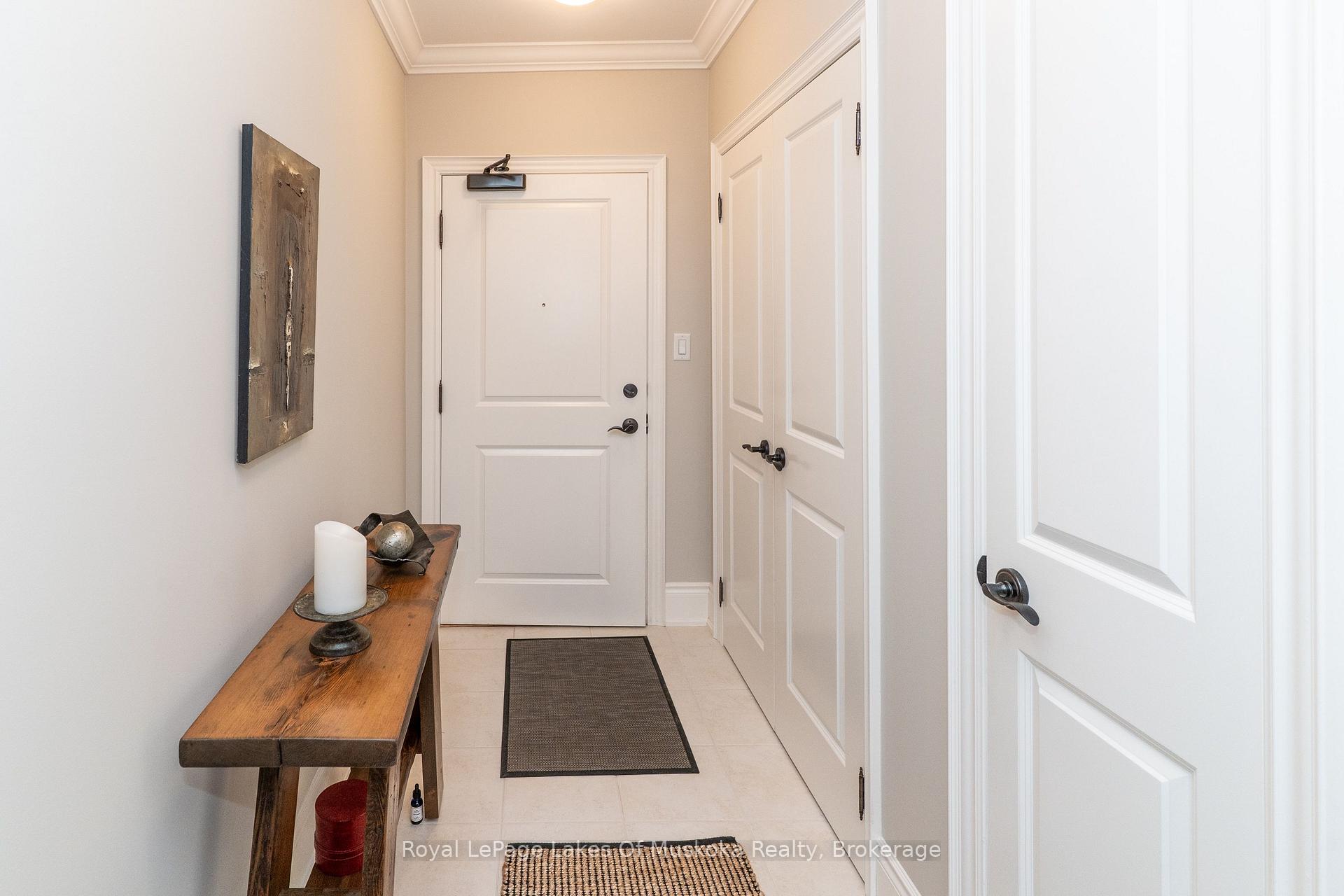 Condo entry hall with a white front door, tiled floor, and rustic console table.