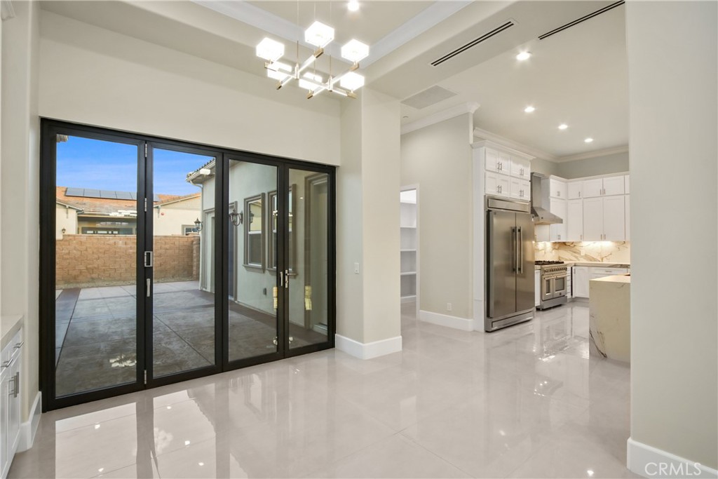 Open dining area and kitchen with glossy tile floors and sliding glass doors to a patio.