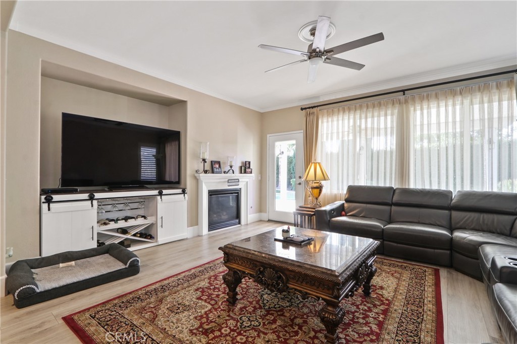 Living room with a leather sectional, ornate coffee table, fireplace, and large wall-mounted television.