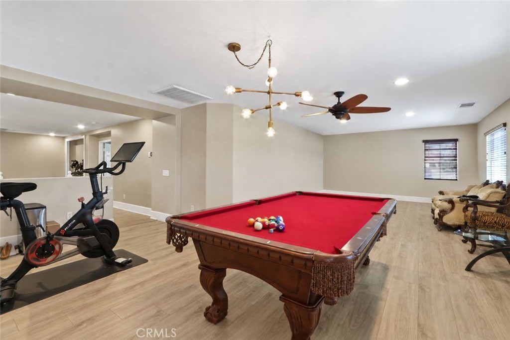 Game room with a red-felt pool table and exercise bike.