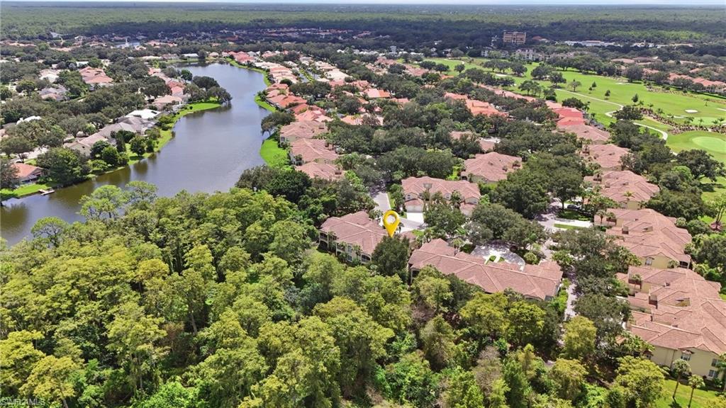 Aerial view of a Naples home marked by a yellow pin, near a winding lake and golf course.