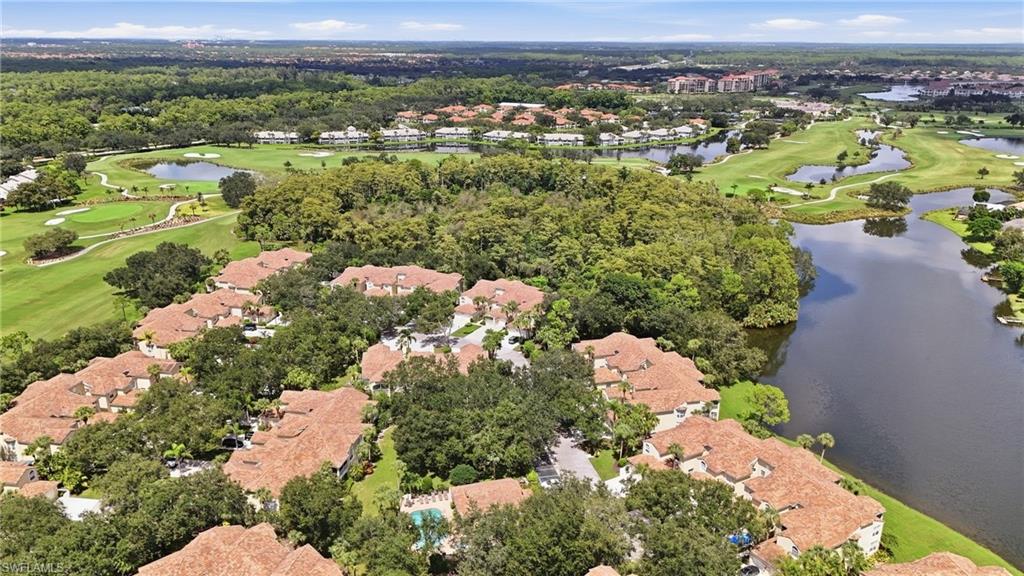 Aerial view of homes beside a lake, with golf course fairways and ponds beyond.