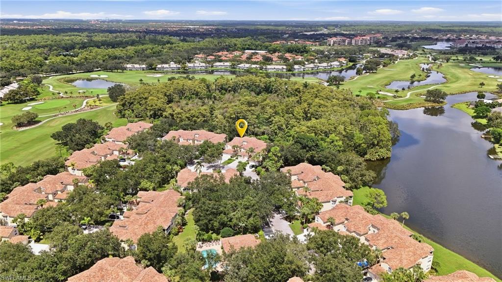 Aerial homes beside golf course and lake, with a marker on one residence.