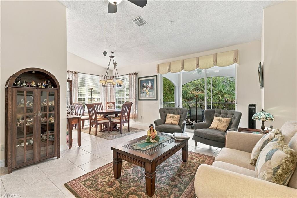 Furnished living and dining room with a display cabinet and sliding doors to a screened lanai.