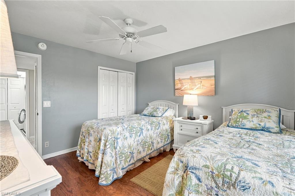 Bedroom with two twin beds in tropical floral bedding and gray walls.