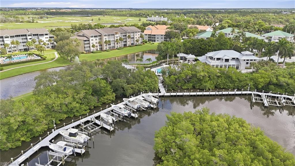 Aerial view of waterfront condos and boat docks along a wooded shoreline.
