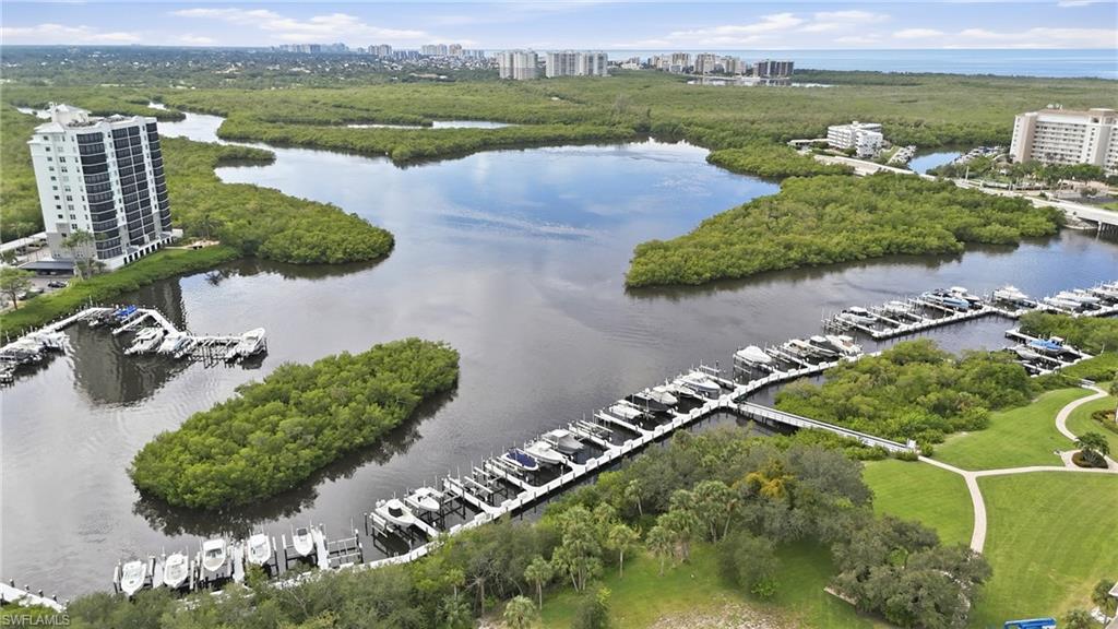 Aerial view of a marina with boats, mangrove-lined waterways, and waterfront buildings.