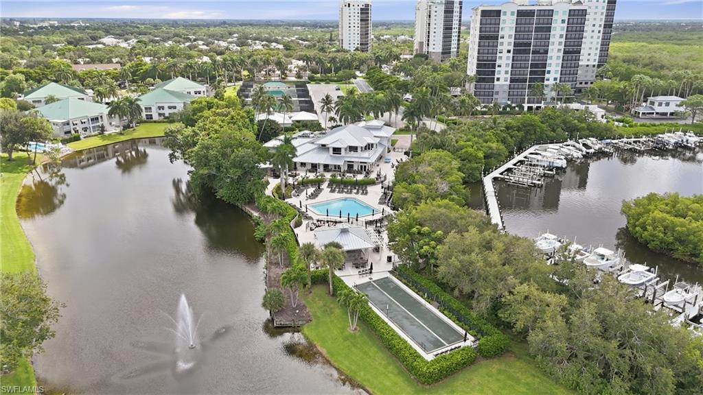 Waterfront condominium community with marina, pool, and tennis court seen from above.