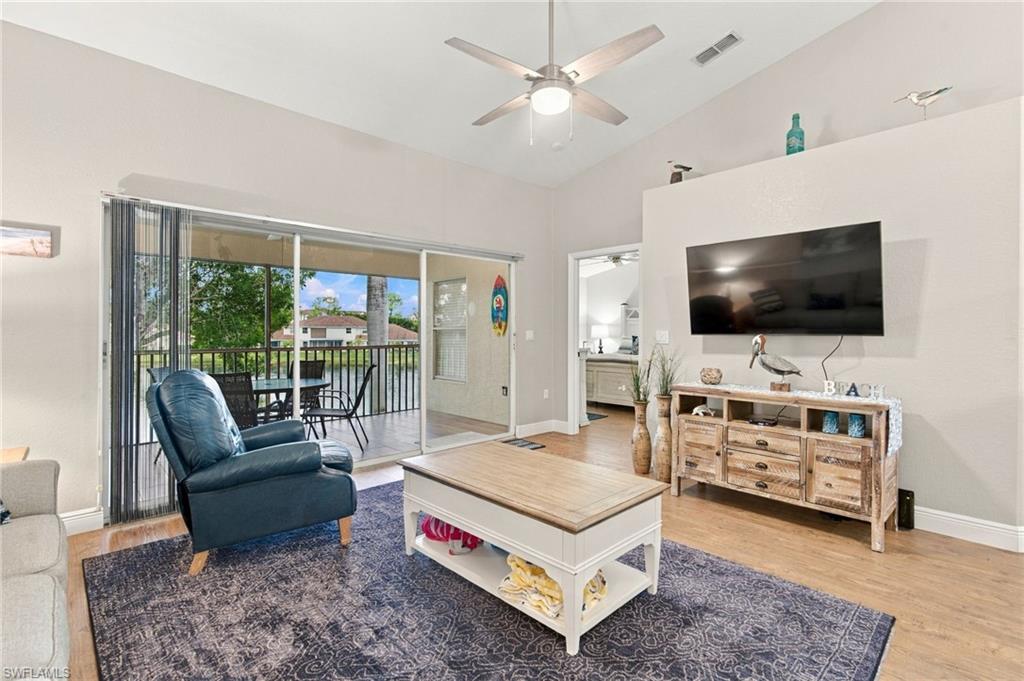 Living room with a blue recliner and sliding doors opening to a screened lanai.