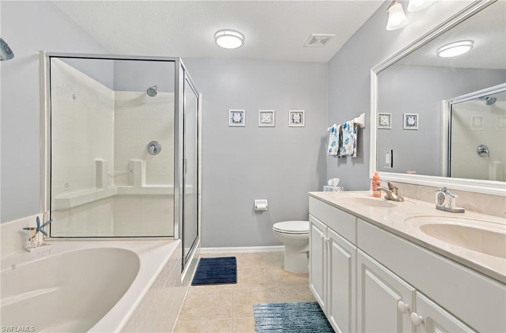 Bathroom with a glass-enclosed shower, soaking tub, and long white vanity.