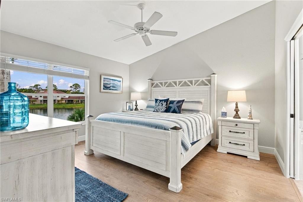 Bedroom with a white bed and blue-and-white bedding overlooking a waterway.