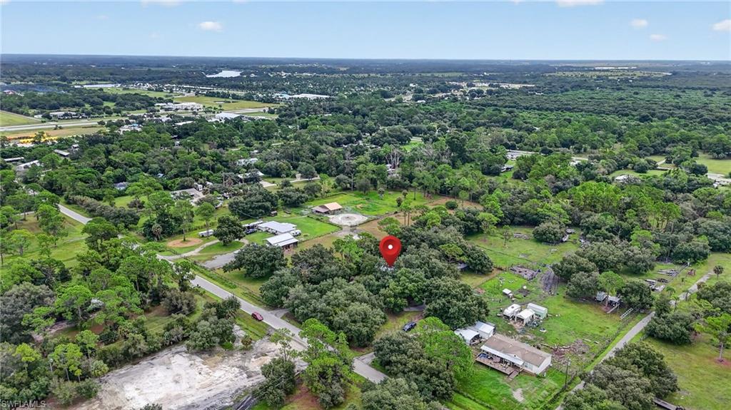 Aerial view of wooded rural acreage marked by a red location pin.