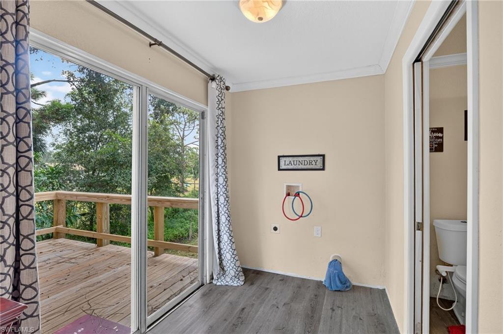 Laundry room with washer hookups and a sliding glass door opening onto a wooden deck.