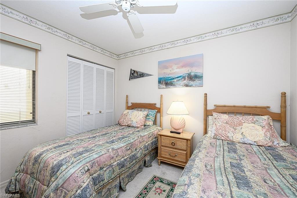 Bedroom with two twin beds, patterned quilts, and a shared wooden nightstand.