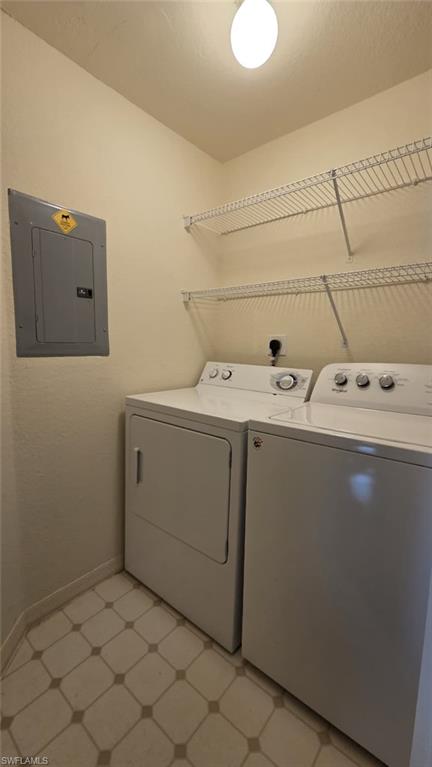 Laundry room with a white washer and dryer beneath wire shelving.