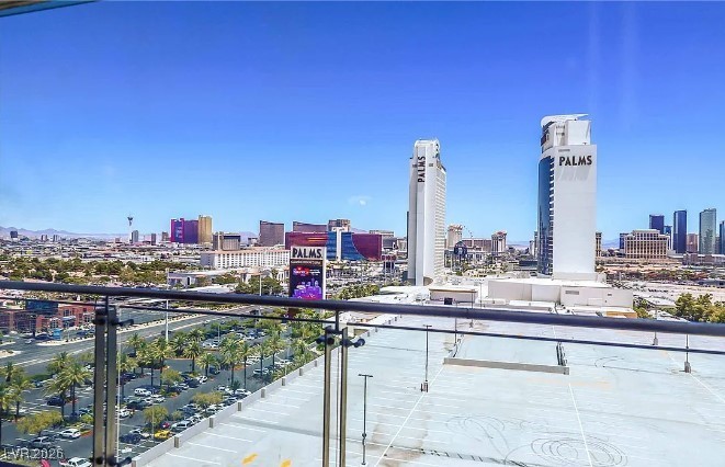 Las Vegas skyline and PALMS towers viewed over a glass-railed balcony.