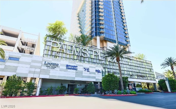 Palms Place high-rise with a glass tower, landscaped entrance, and palm trees.