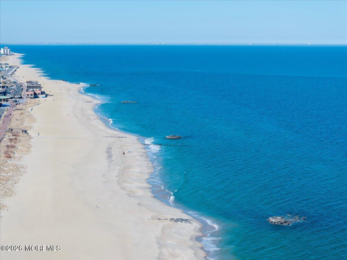 Aerial view of a broad sandy beach and blue ocean along the coastline.
