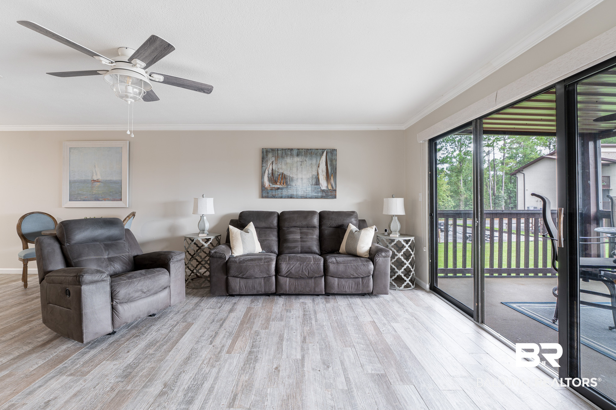 Living room with gray leather seating and sliding glass doors opening to a balcony.