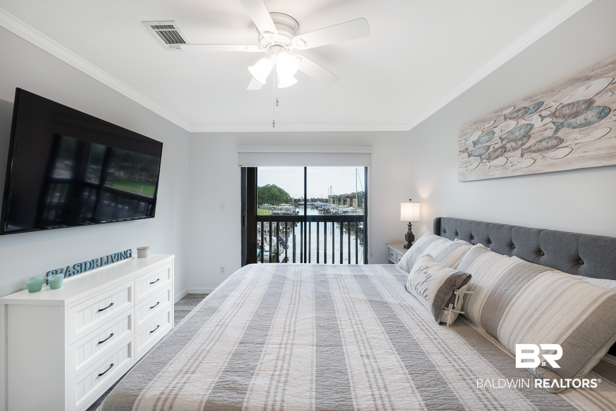 Staged bedroom with a marina view through the sliding glass door.