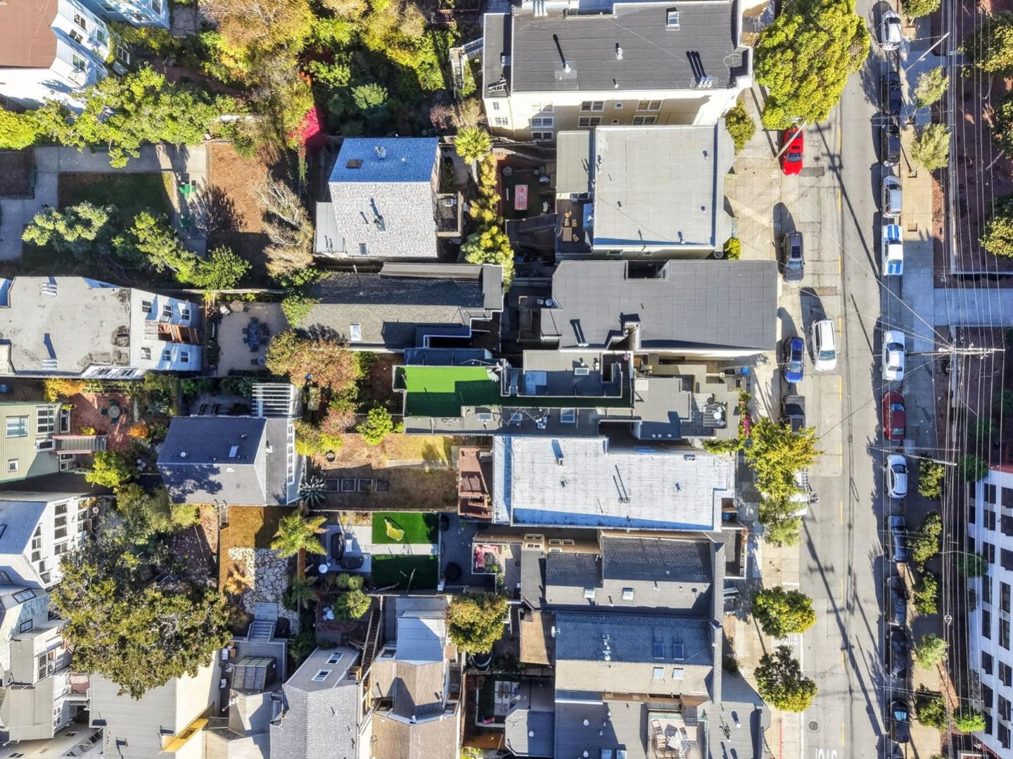 Aerial view of a San Francisco residential block with closely spaced rooftops and leafy yards.