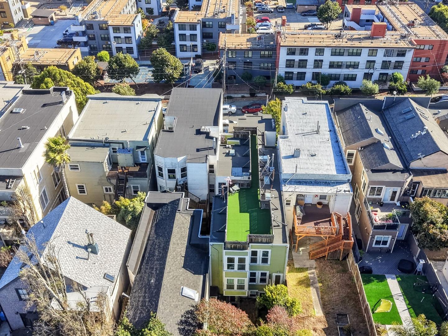 Aerial view of closely spaced San Francisco homes, rooftops, decks, and small yards.