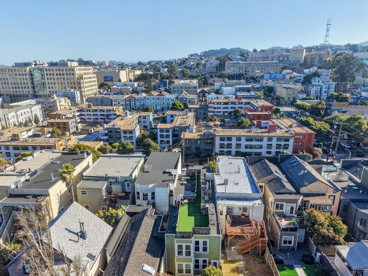 Aerial view over San Francisco rooftops toward hillside neighborhoods.