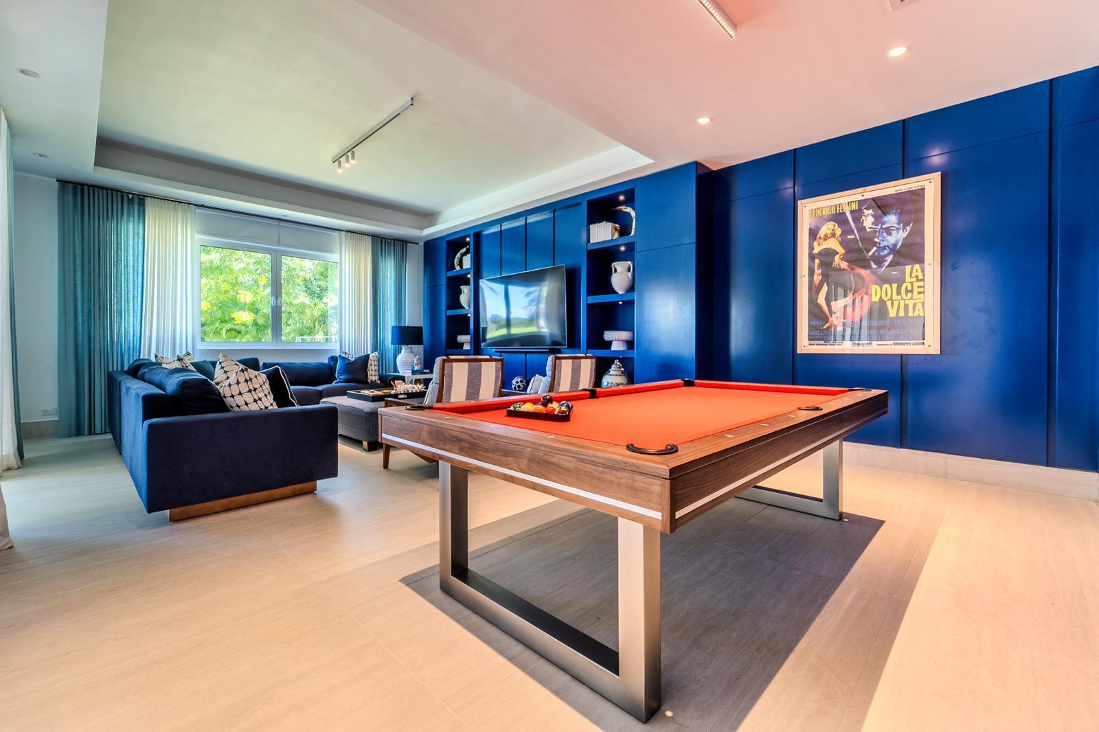 Game room with a red-felt pool table, navy sofa, and blue built-in cabinetry.