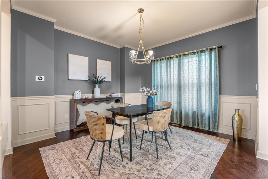 Dining room with woven chairs, a patterned rug, gray walls, and teal curtains.