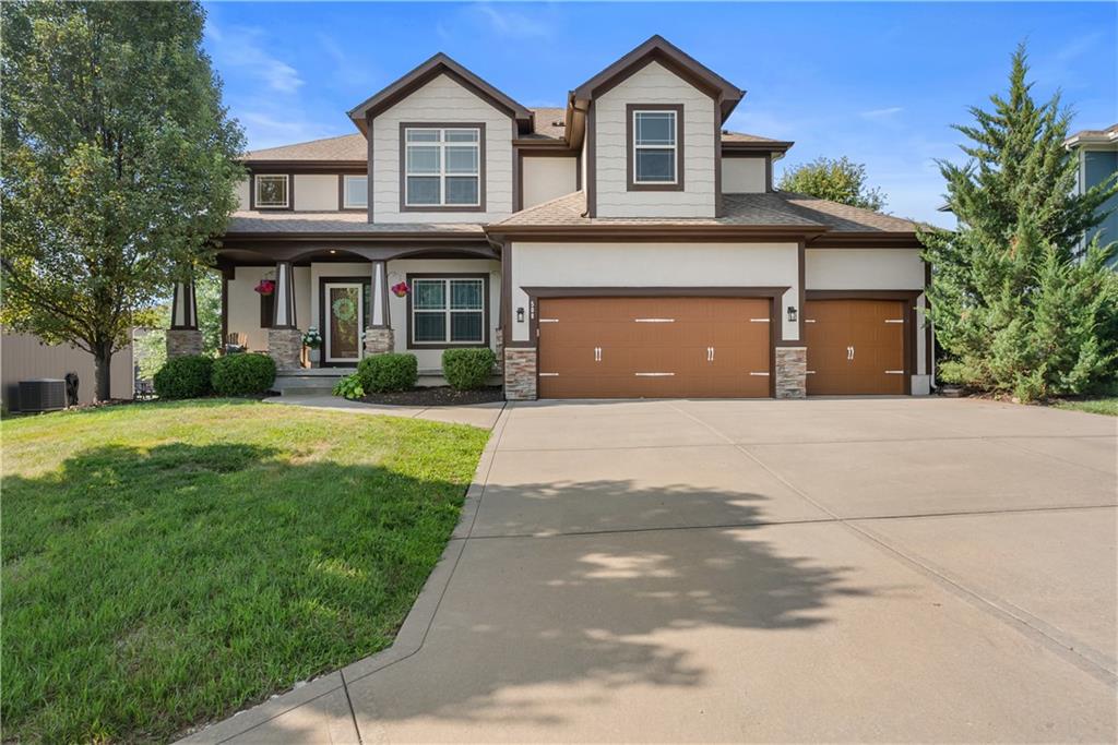Two-story house with stone accents, a covered entry, and a three-car garage.