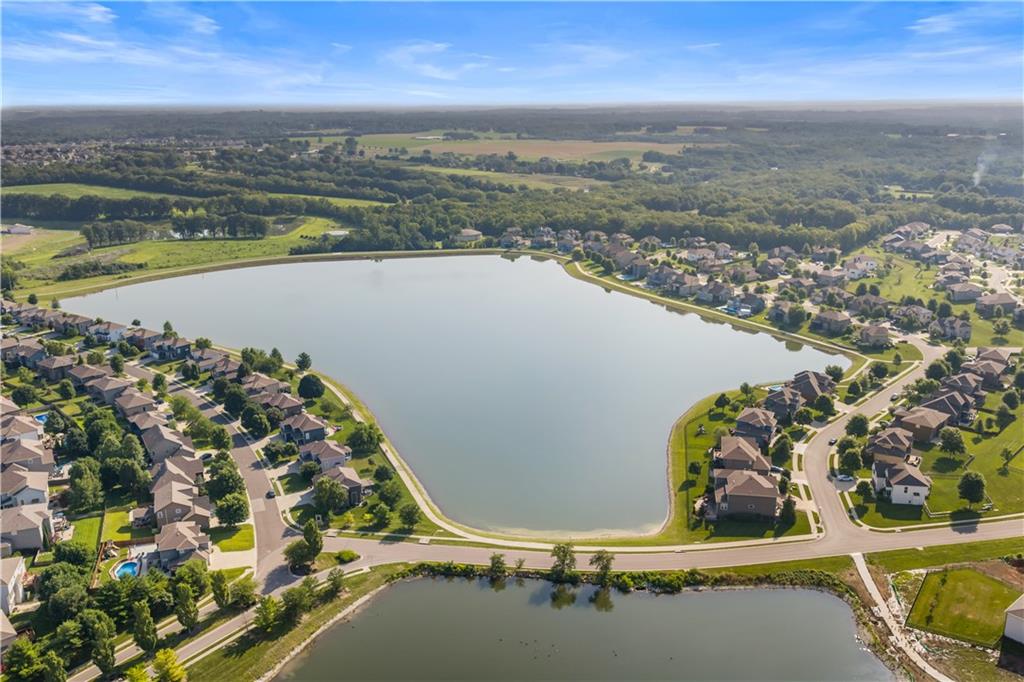 Aerial view of a neighborhood lake surrounded by homes and curving streets.