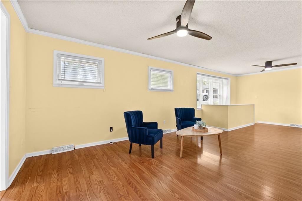 Living room with navy armchairs, a round coffee table, and wood-look flooring.