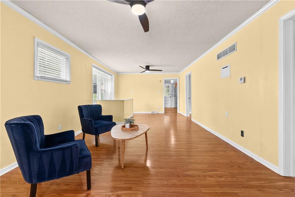Living room with hardwood floors, yellow walls, and two navy armchairs.
