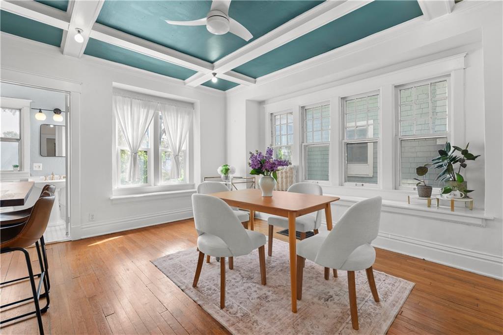 Dining room with a teal coffered ceiling, hardwood floors, and large windows.