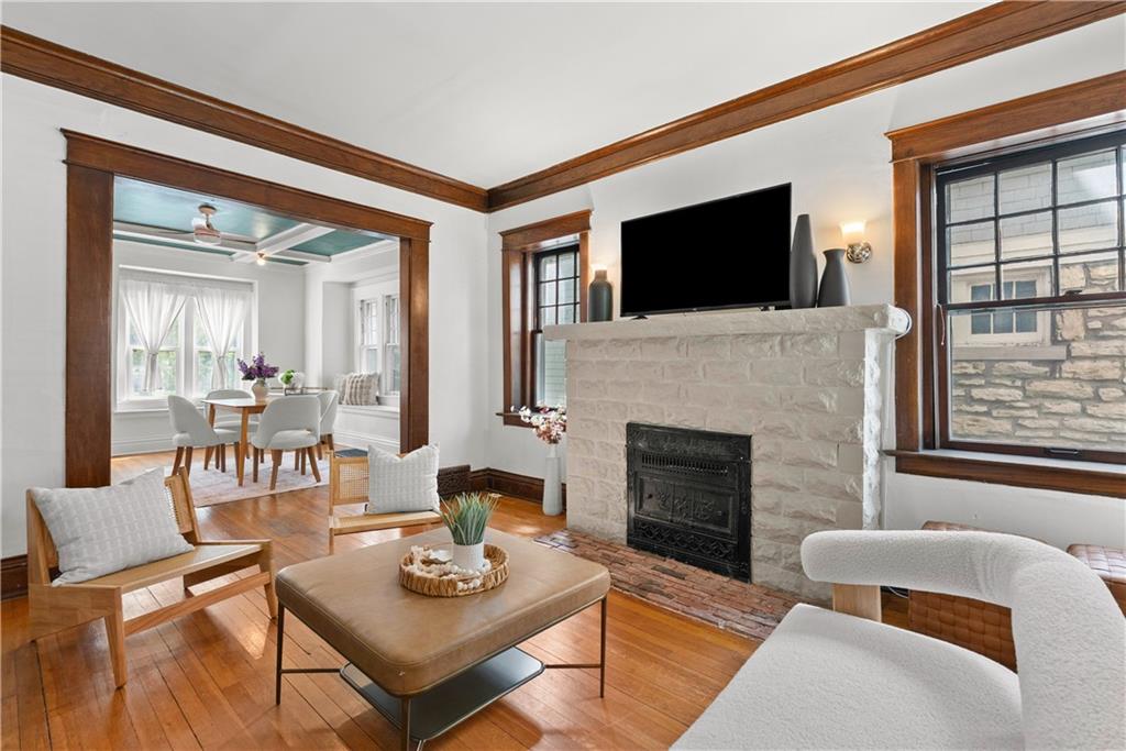 Living room with a white brick fireplace, dark wood trim, and an adjoining dining area.