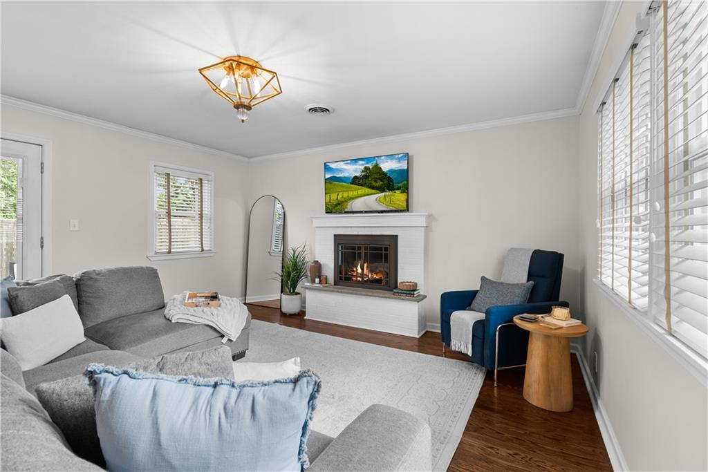 Living room with a gray sectional, blue accent chair, and white fireplace.