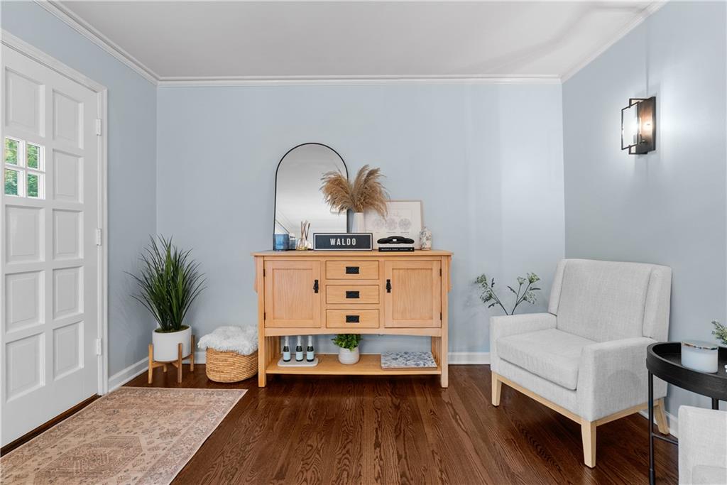 Entryway with a white paneled door, pale blue walls, hardwood floors, and a light wood console.