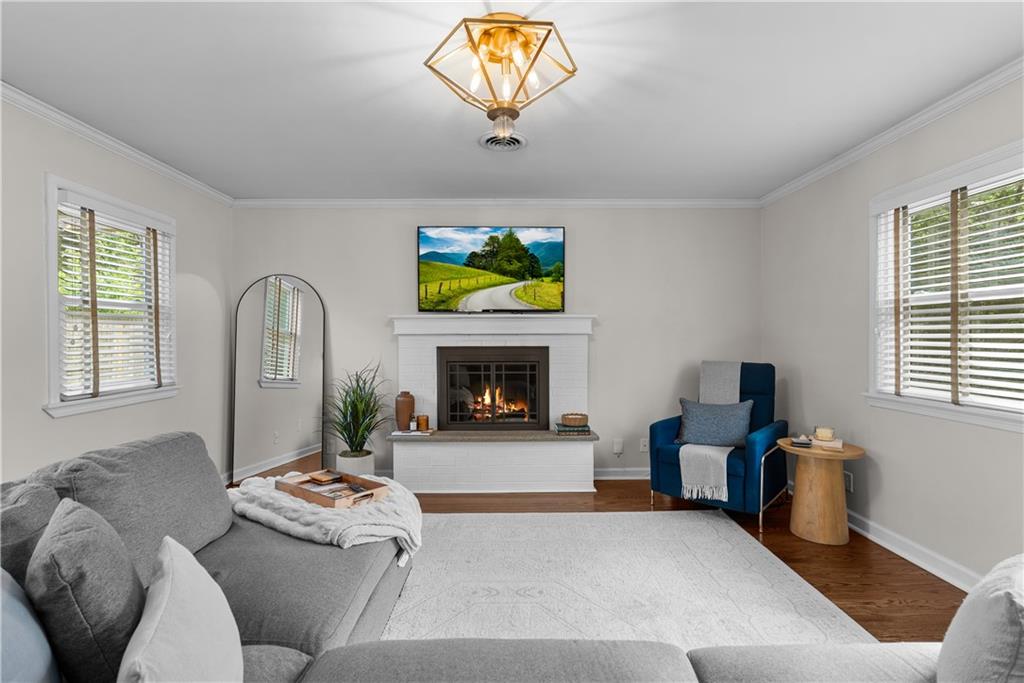 Staged living room with a white fireplace, gray sectional, and blue armchair.