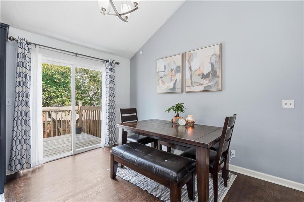 Dining room with a dark wood table and bench beside sliding glass doors to a deck.