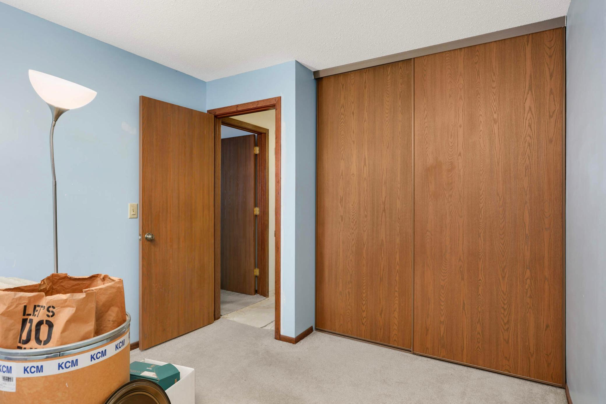 Room with large wood sliding closet doors, an open doorway, and boxes in the foreground.