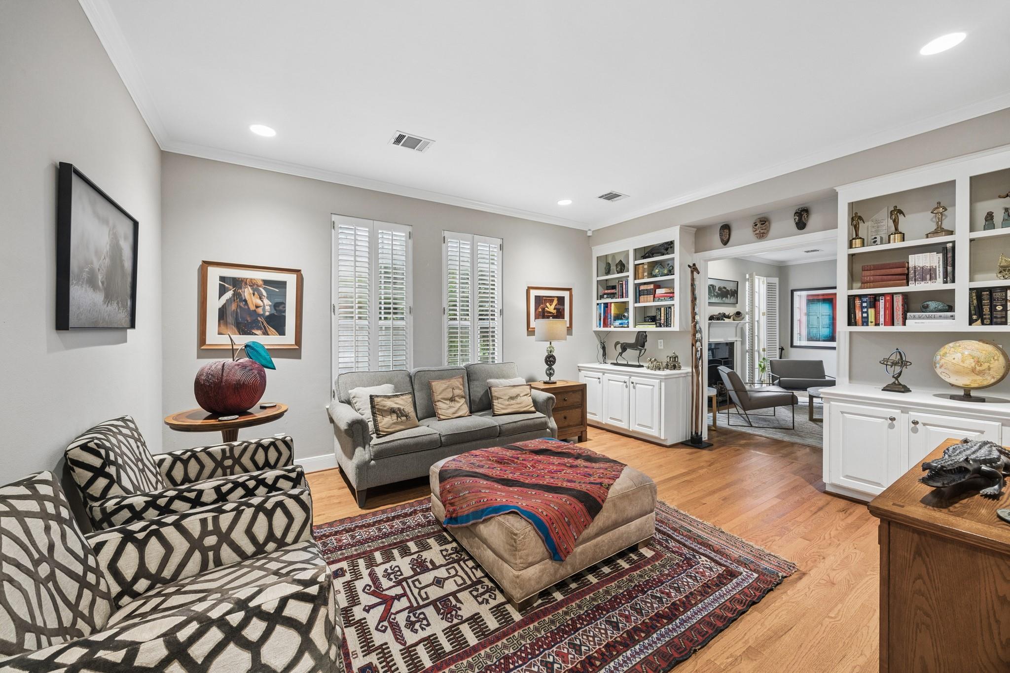 Living room with built-in shelves, gray sofas, and a colorful patterned rug.