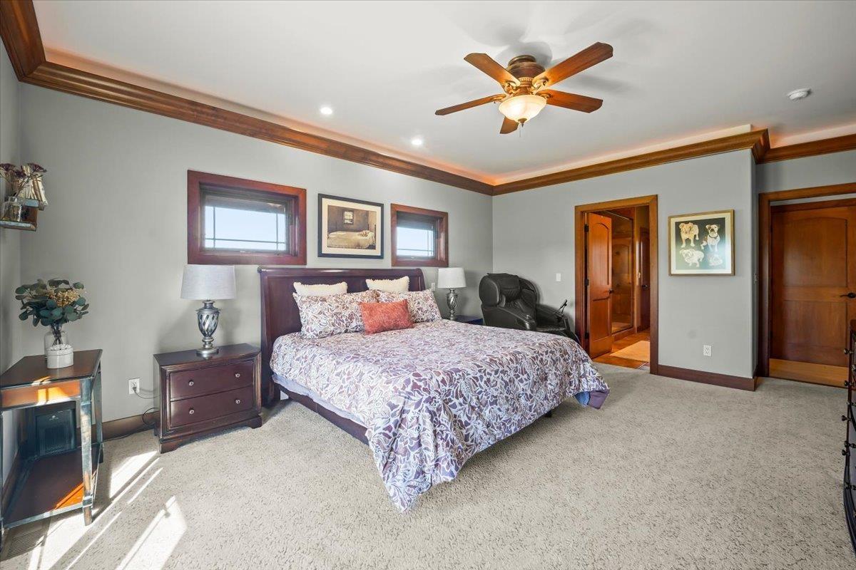 Furnished bedroom with a dark wood bed, patterned bedding, and a ceiling fan.