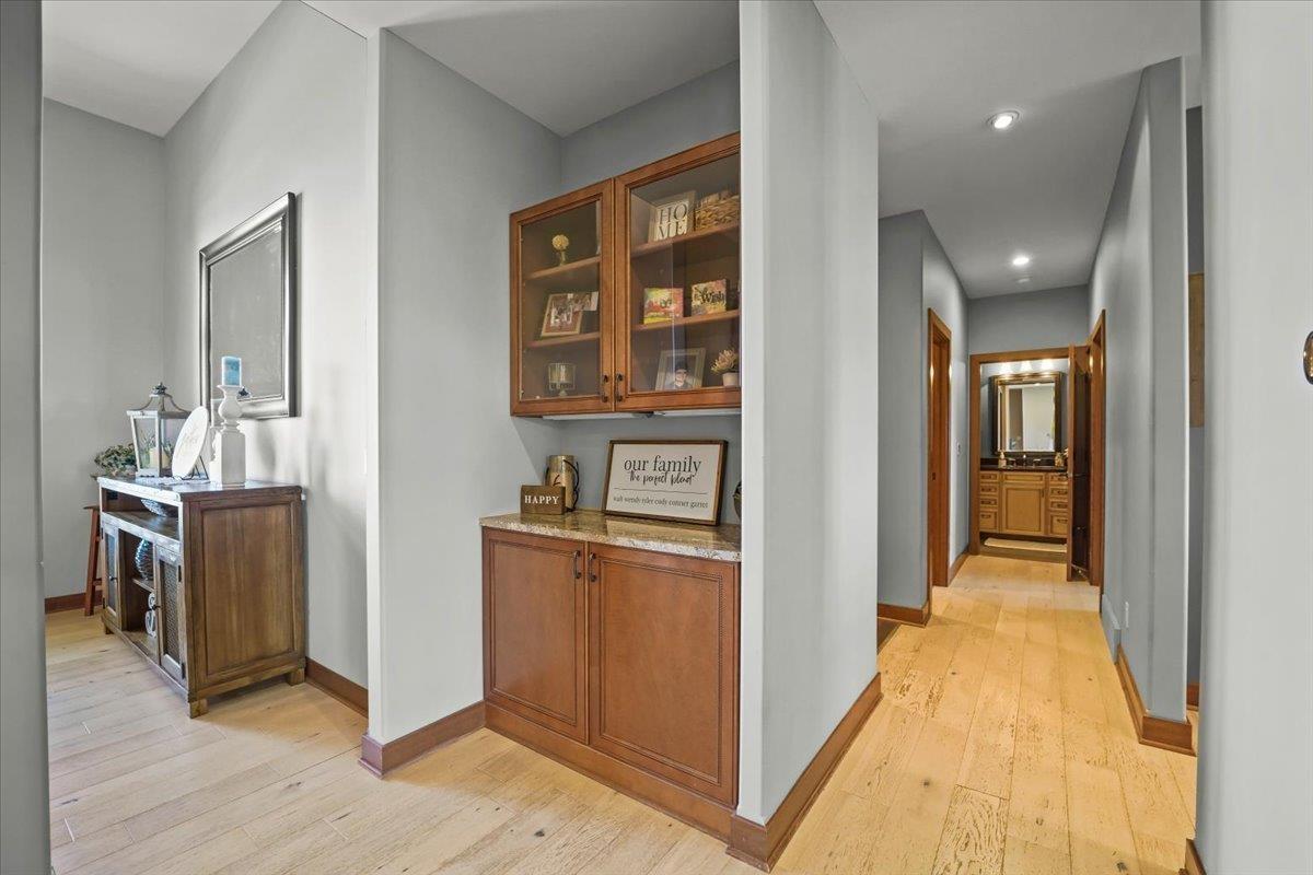Hallway with built-in wood cabinets and a view through to a bathroom vanity.