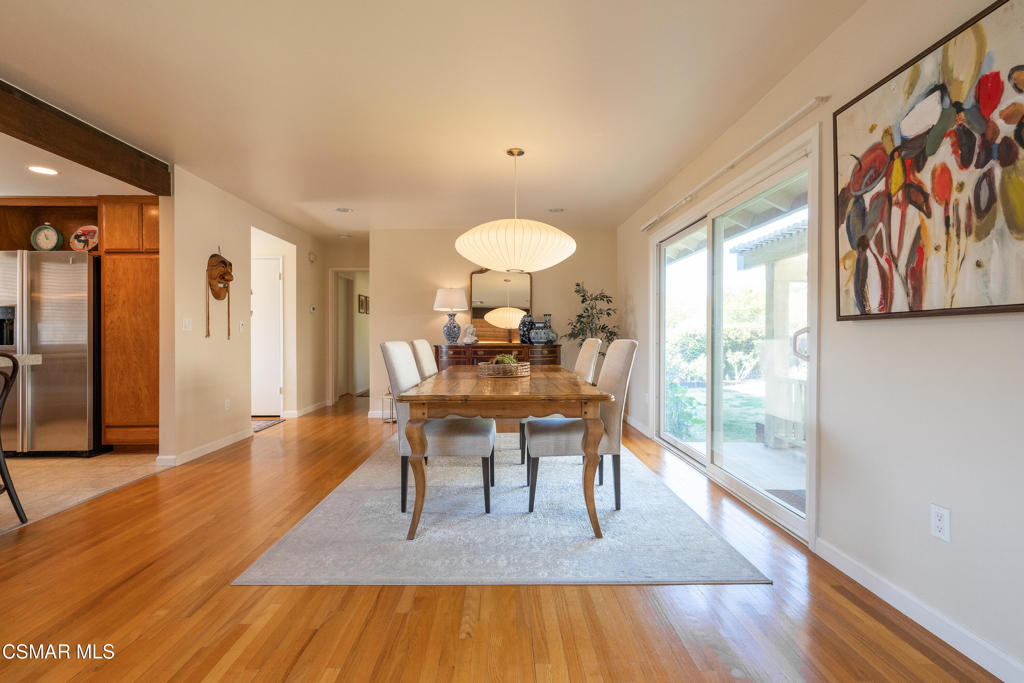 Dining room with a wooden table, hardwood floors, and sliding glass doors to the yard.