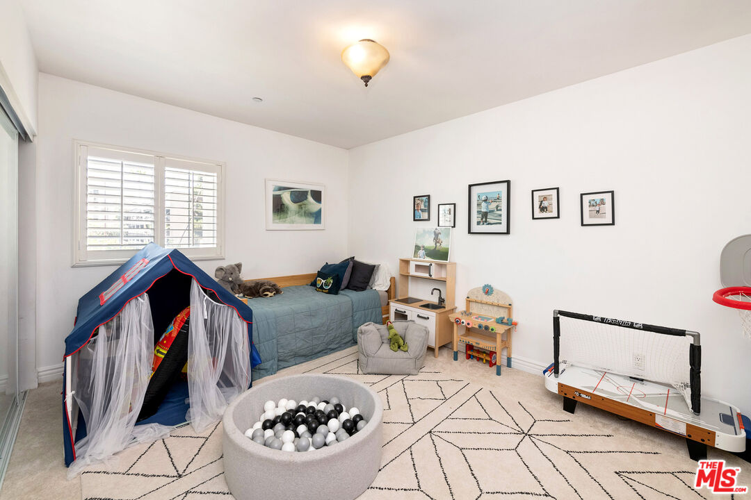 Child’s bedroom with a play tent, ball pit, and tabletop hockey game beside a twin bed.