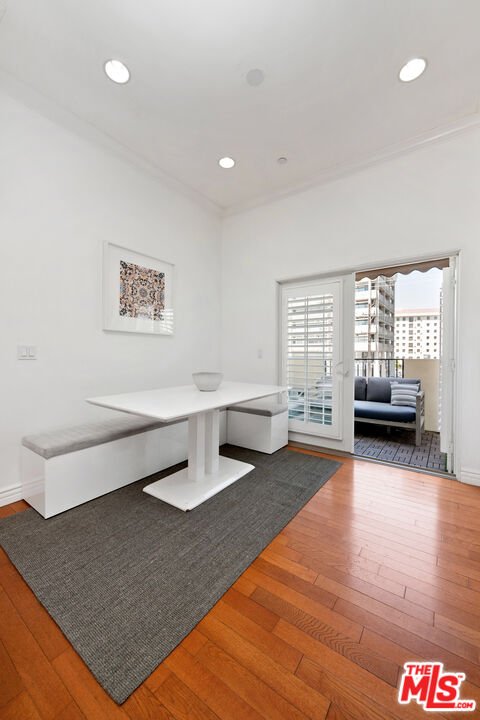 Dining nook with a white table and built-in bench opening onto a small balcony.