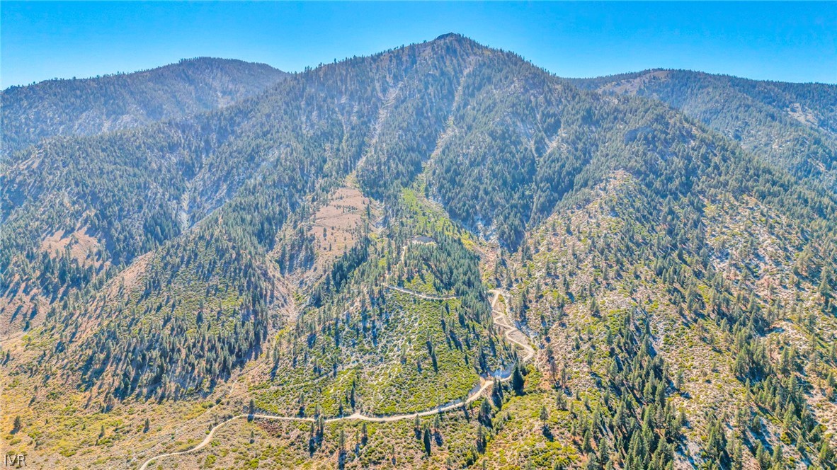 Aerial view of rugged mountain terrain with a winding dirt road.